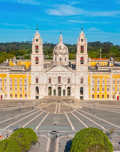 National Palace of Mafra facade with twin bell towers and baroque architecture in Lisbon, Portugal.