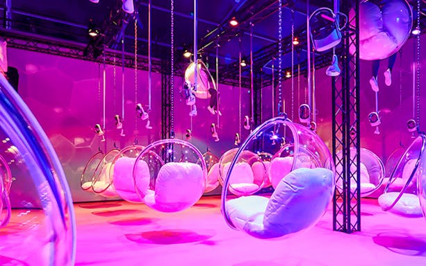 Bubble chairs and VR headsets in a vibrant room at Bubble Planet An Experience Museum.