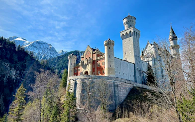 Neuschwanstein Castle with mountain backdrop, part of Munich train tour.