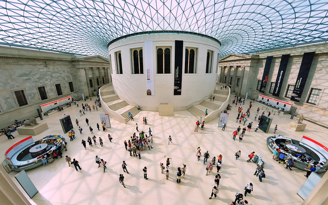 Visitors in the Great Court of the British Museum, London, under the glass roof.
