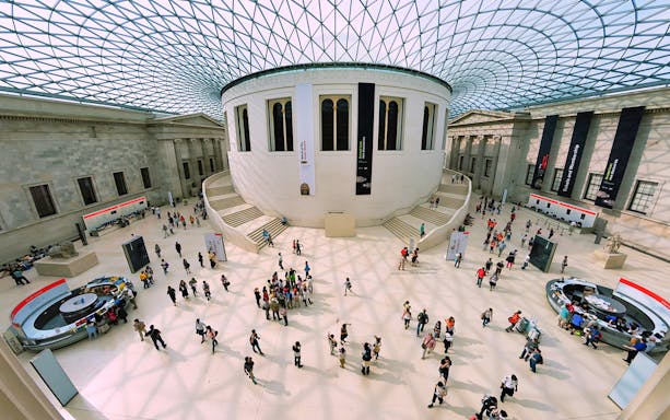 Visitors in the Great Court of the British Museum, London, under the glass roof.