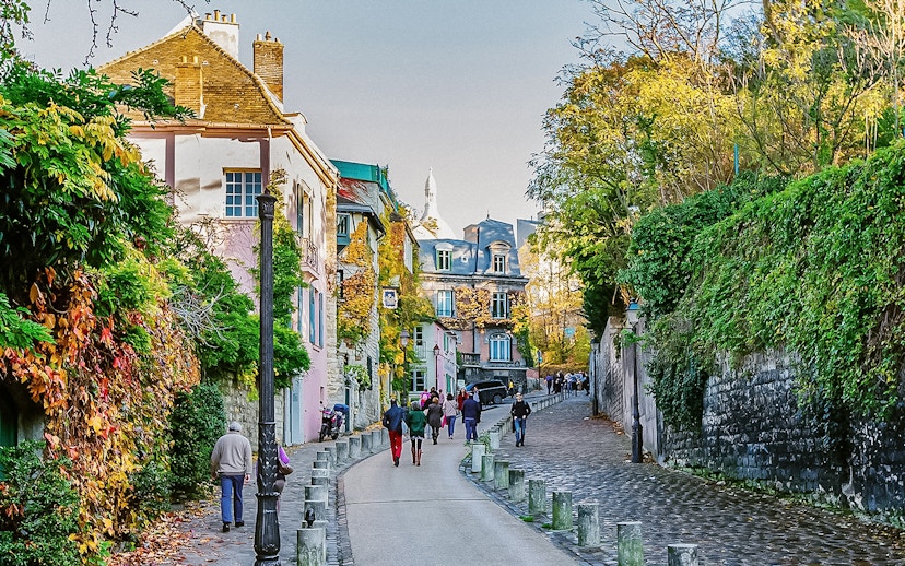 Montmartre street scene with colorful buildings and people walking, Paris.