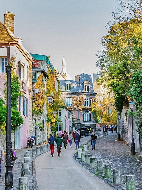 Montmartre street scene with colorful buildings and people walking, Paris.
