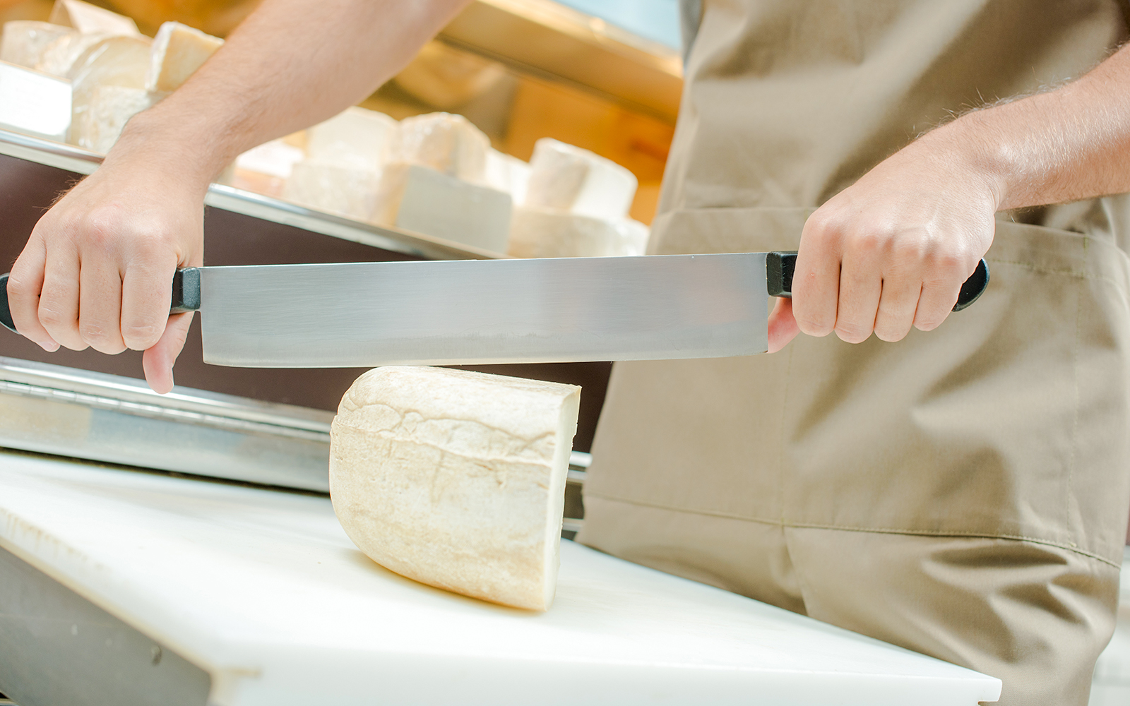 Server slicing cheese at Cheese Museum in Paris.