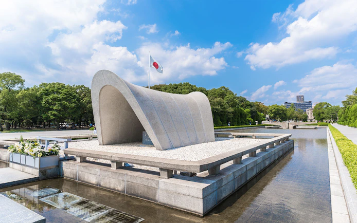Hiroshima Peace Memorial Park cenotaph with Japanese flag in background.