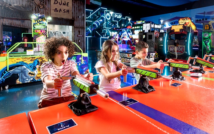 Children playing arcade games at Play DXB indoor amusement park.