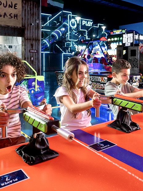 Children playing arcade games at Play DXB indoor amusement park.