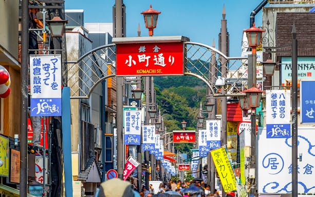 Komachi Street entrance in Kamakura, bustling with visitors and colorful signs.