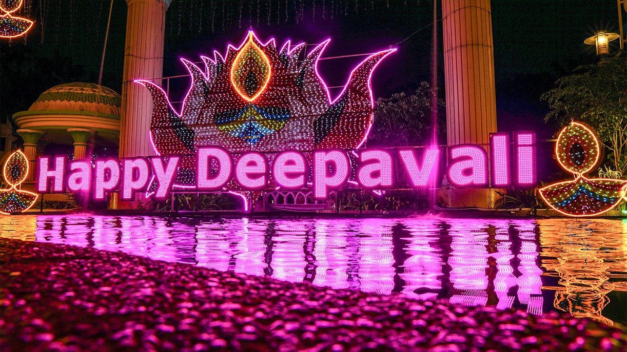 People celebrating Diwali with fireworks and lights in a vibrant city setting.