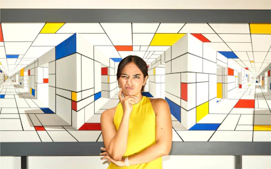 Person posing in front of geometric illusion art at IAM Illusion Art Museum Prague.