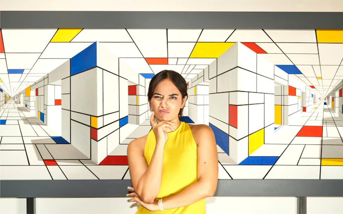 Person posing in front of geometric illusion art at IAM Illusion Art Museum Prague.