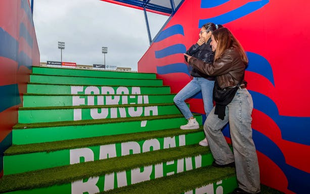 Visitors walking up stadium steps with "Força Barça" signage during Match Day Tour.