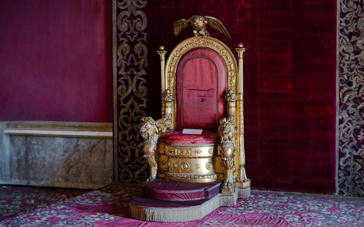 Throne in the Royal Palace of Naples with ornate gold and red design.