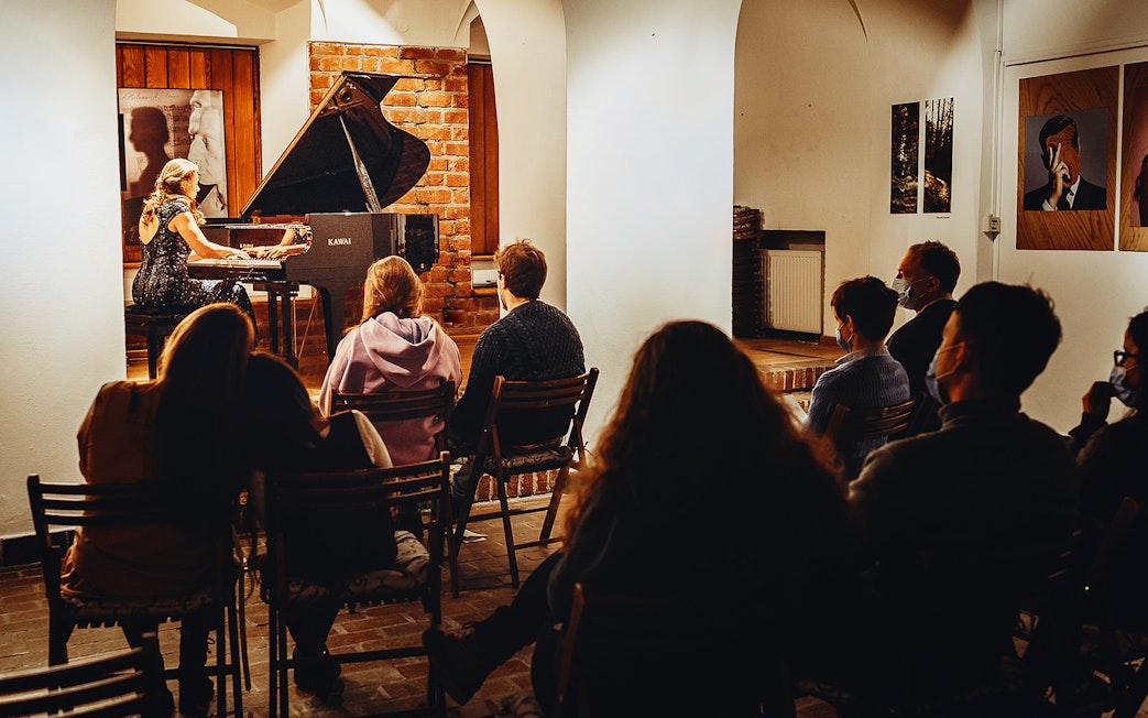 Pianist performing Chopin at Old Town recital with audience seated.