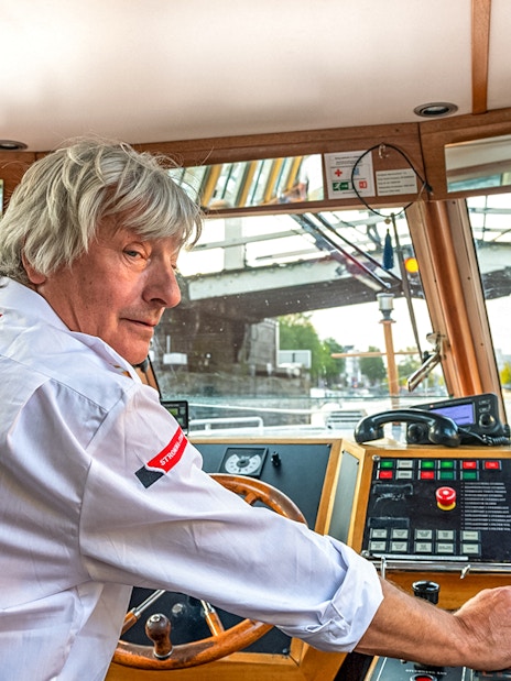 Boat captain steering during Amsterdam city centre cruise.