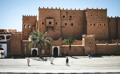 Ait Ben Haddou kasbah with palm trees, part of Ouarzazate day trip from Marrakech.