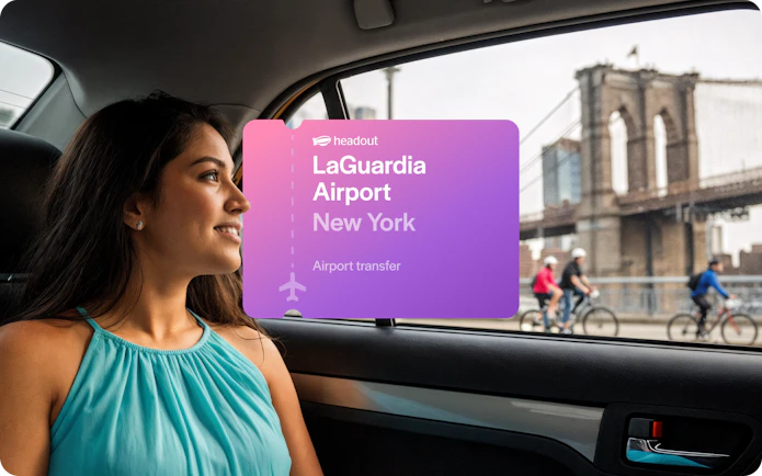 Woman in car with view of Brooklyn Bridge, New York, during LaGuardia Airport transfer.