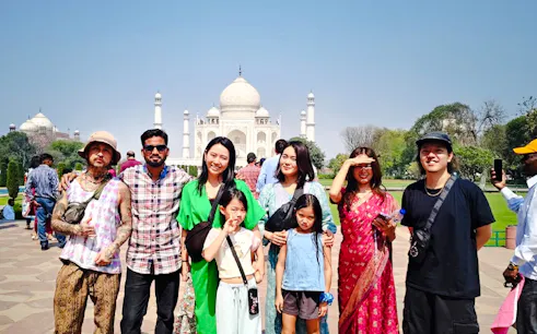 Group of tourists at Taj Mahal during sunrise on Agra trip from Delhi.