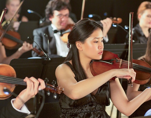 Musicians playing violins at a classical concert in Vienna.