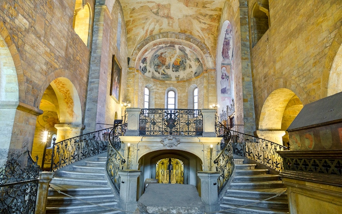 Basilica of St George interior with ornate staircase and frescoed ceiling.