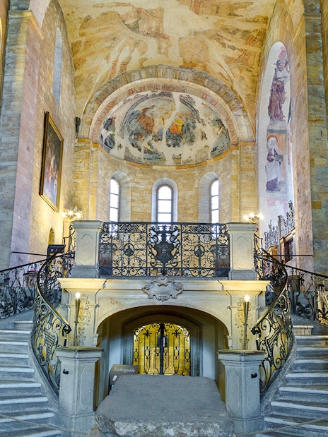 Basilica of St George interior with ornate staircase and frescoed ceiling.