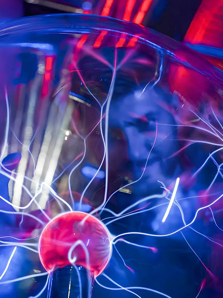 Plasma ball exhibit at DeJa Vu Museum with glowing electric strands.