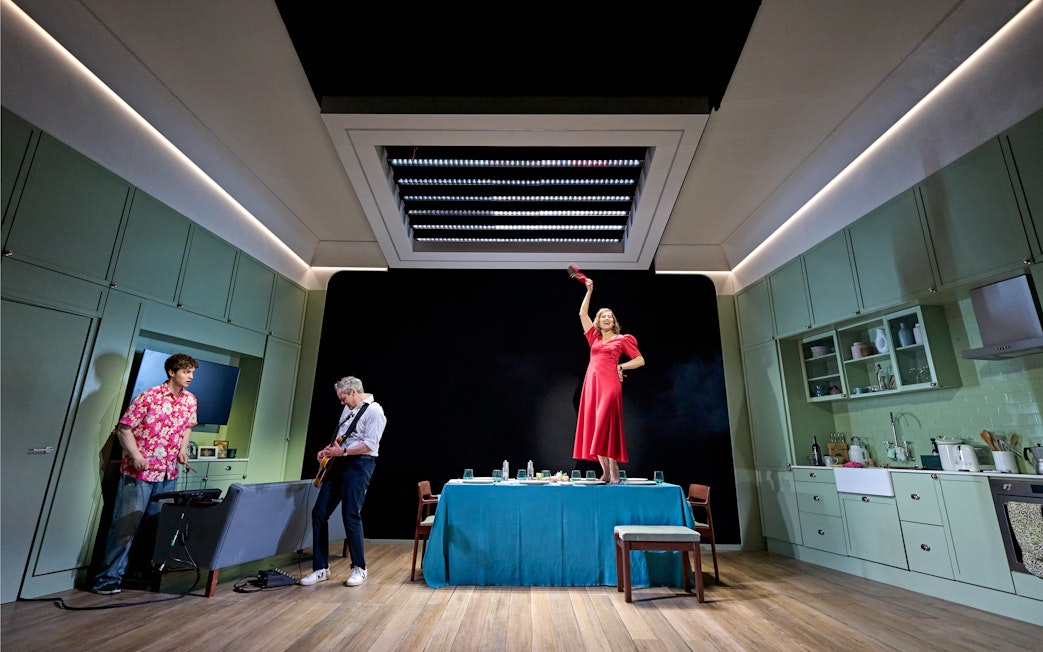 Actors performing a scene in a modern kitchen set during "Inter Alia" at West End.