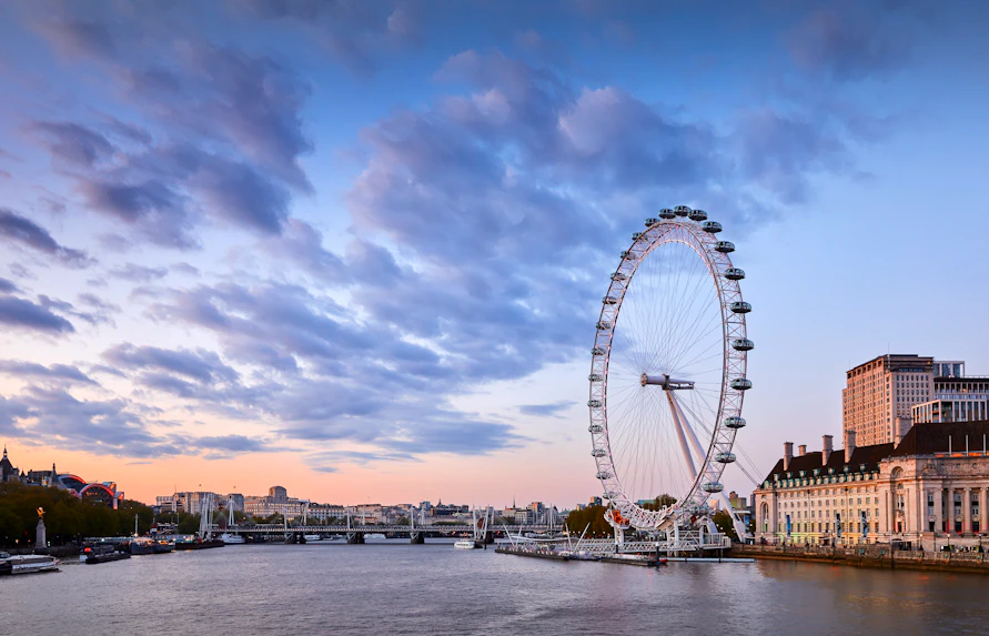 London Eye overlooking the Thames River at sunset.