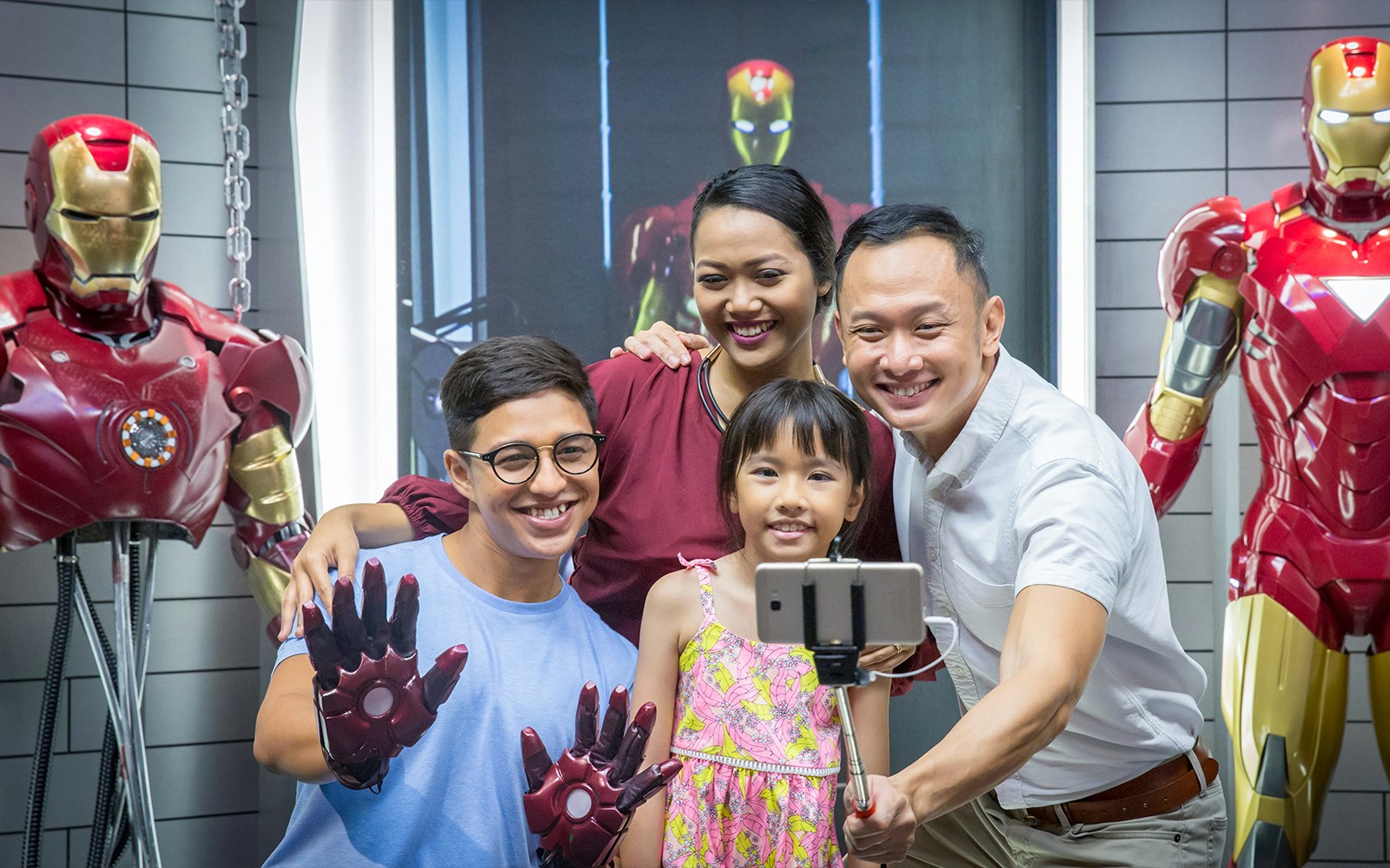 Family taking selfie with Iron Man figures at Madame Tussauds Singapore.