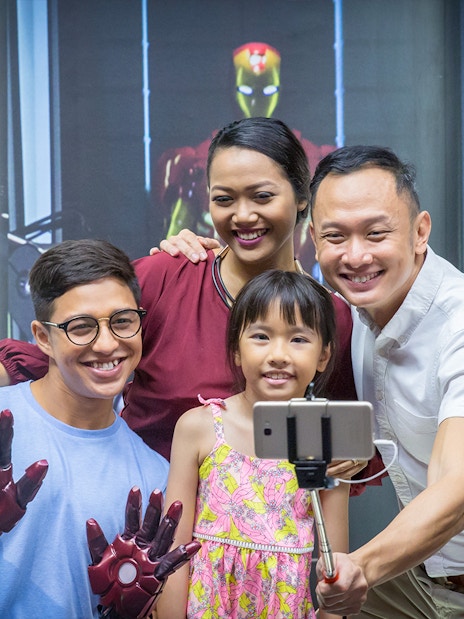 Family taking selfie with Iron Man figures at Madame Tussauds Singapore.