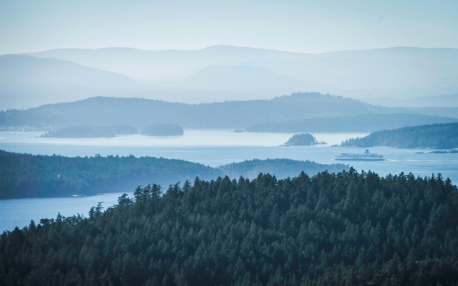 Misty morning view of islands and ferry from Pender Island, Gulf Islands, Vancouver.