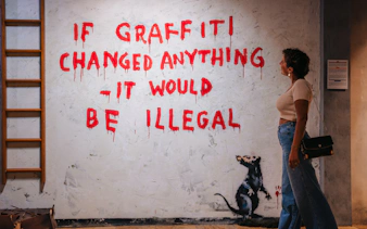 Tourist viewing graffiti art at Banksy Museum Barcelona.