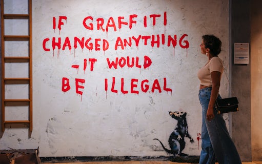 Tourist viewing graffiti art at Banksy Museum Barcelona.