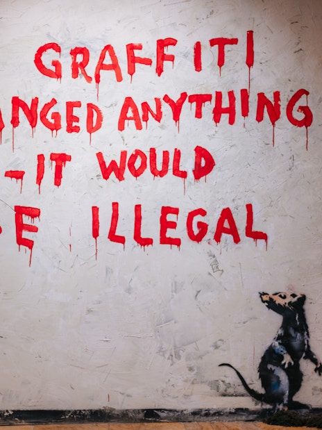 Tourist viewing graffiti art at Banksy Museum Barcelona.