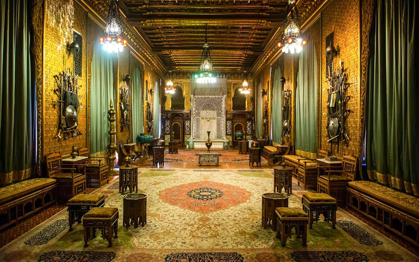 Ornate interior of Peleș Castle with intricate woodwork and decorative armor displays.