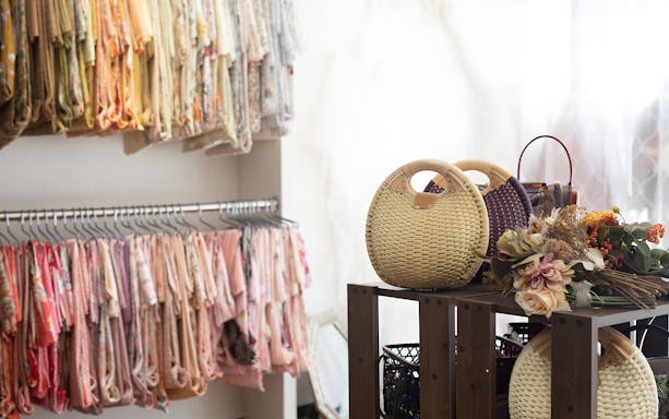 Kimono rental shop in Kyoto with colorful kimonos and woven bags on display.