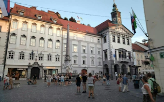 Ljubljana Town Hall and Robba Fountain with tourists exploring the square.