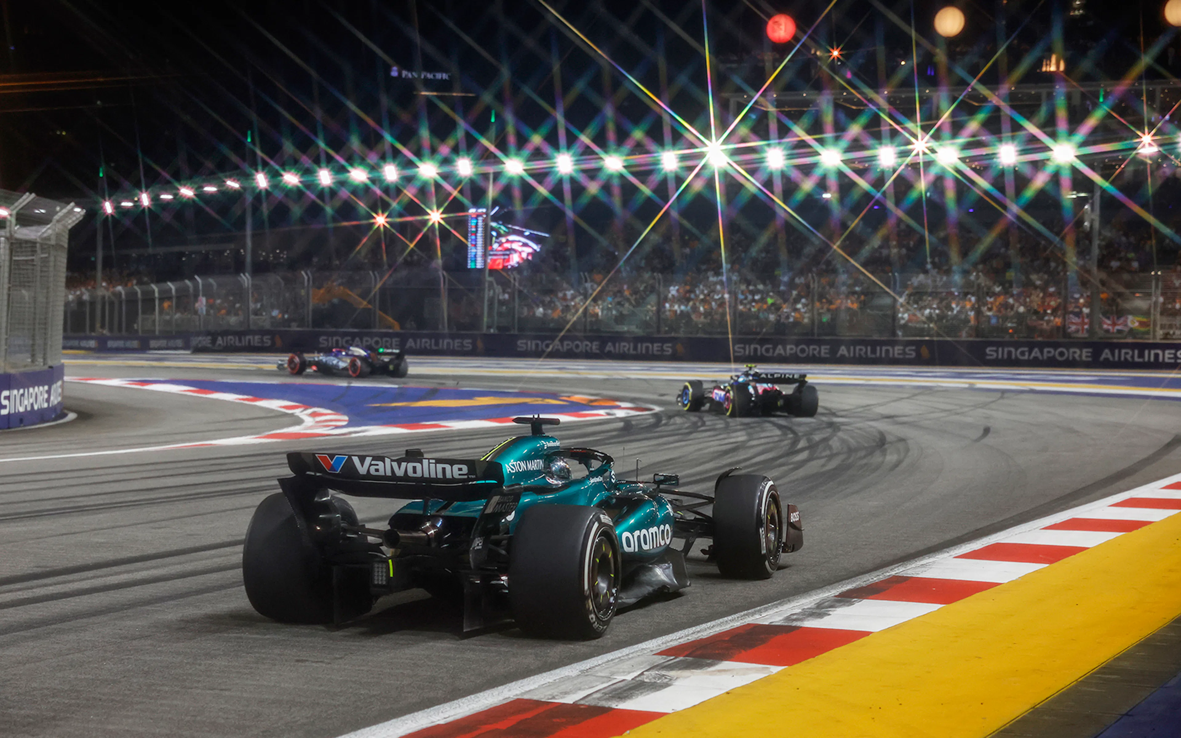 Race cars on track at night during Formula 1 Singapore Grand Prix 2025.