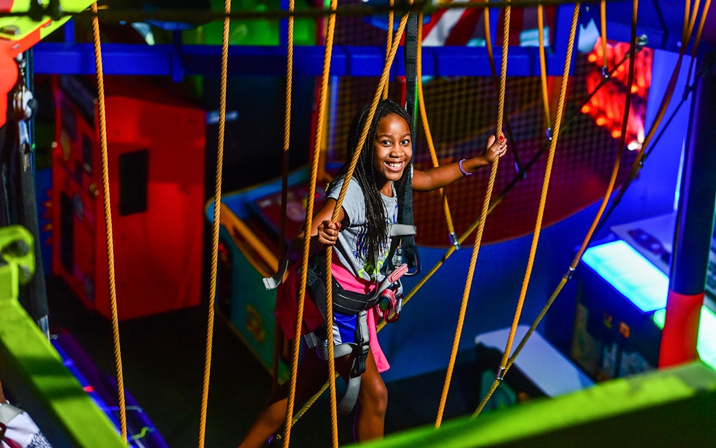 Child enjoying a ropes course at Wonderworks indoor amusement park.