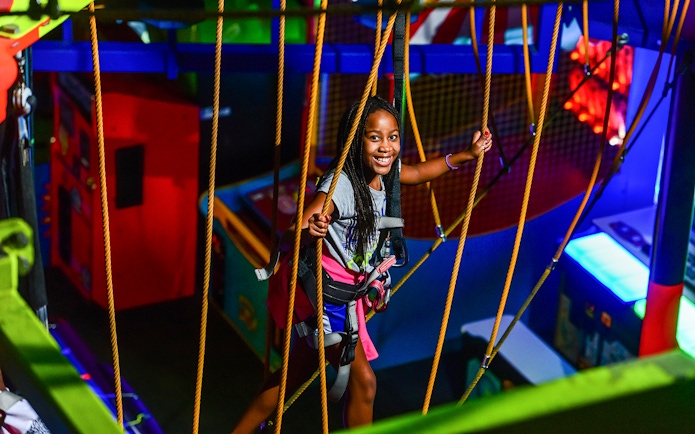 Child enjoying a ropes course at Wonderworks indoor amusement park.