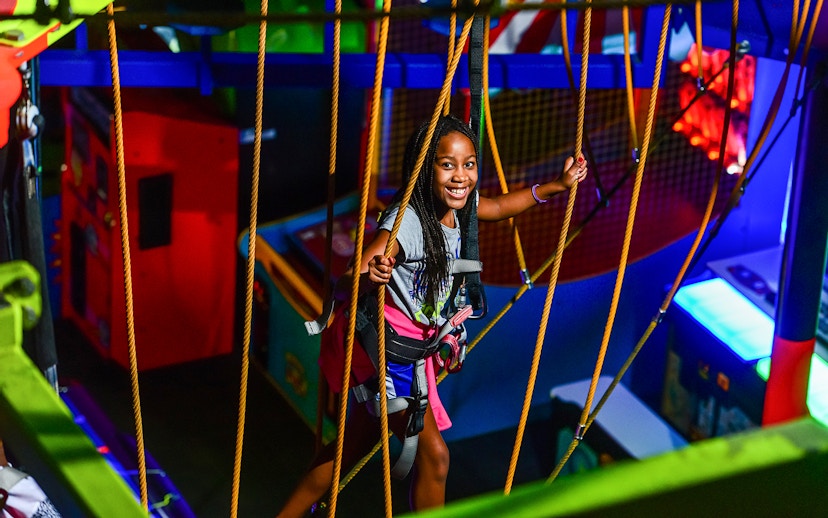 Child enjoying a ropes course at Wonderworks indoor amusement park.