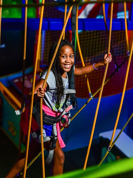 Child enjoying a ropes course at Wonderworks indoor amusement park.