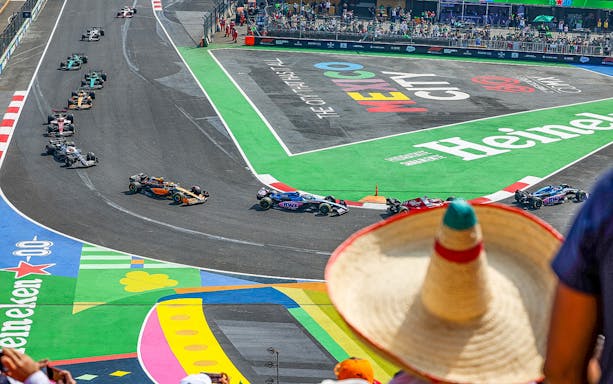 Race cars on track at Formula 1 Mexico Grand Prix, Mexico City, with spectators.