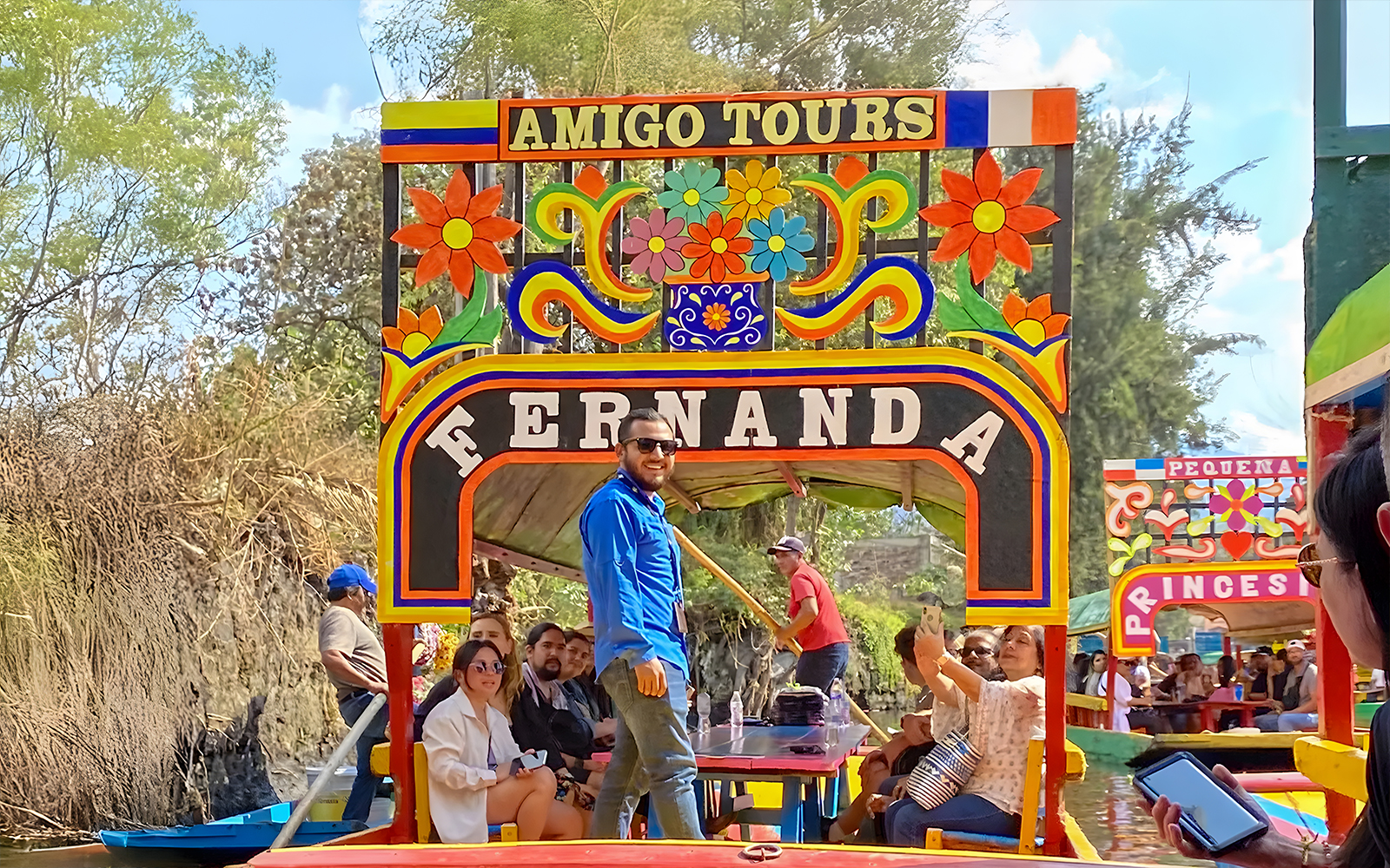 Trajinera boat with tourists on Xochimilco canal, Mexico City.