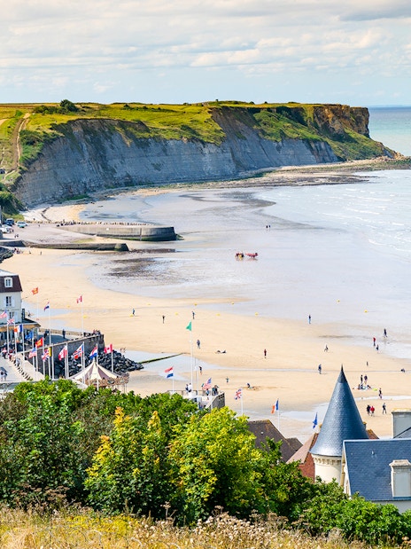 Arromanches Les Bains beach with cliffs and village in Normandy, France.