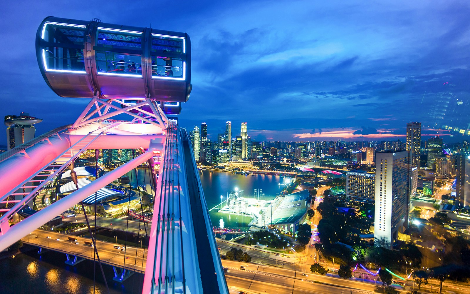 Singapore Flyer cabin illuminated for New Year's Eve, overlooking city skyline and Marina Bay.