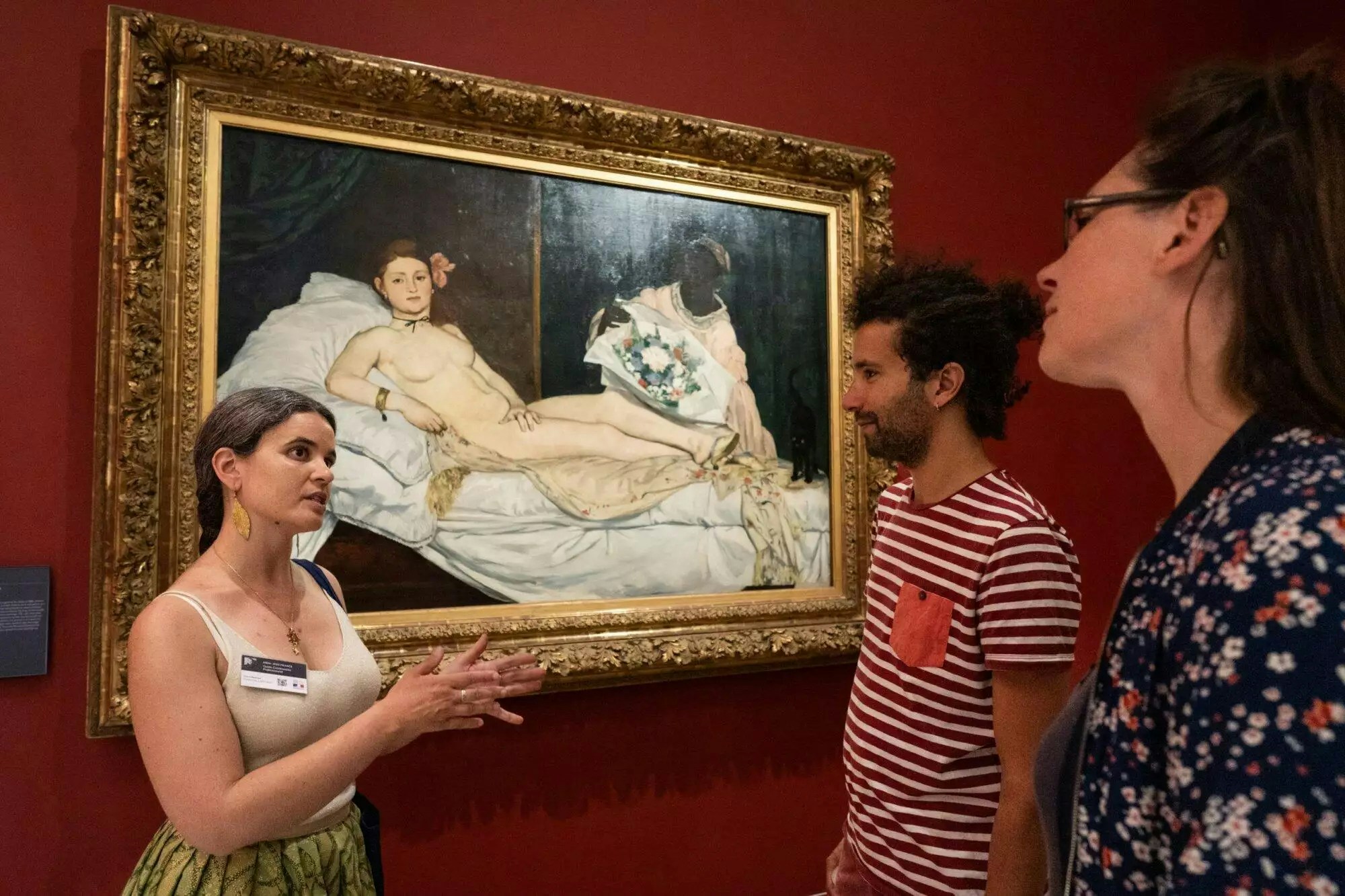 Guide explaining Manet's Olympia painting at Orsay Museum, Paris, France.