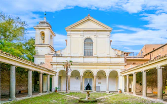 Courtyard of Basilica of San Clemente, Rome, with arches and bell tower.
