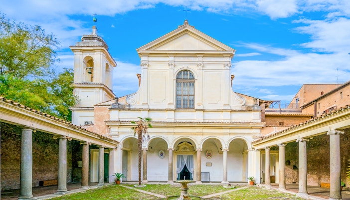 Courtyard of Basilica of San Clemente, Rome, with arches and bell tower.