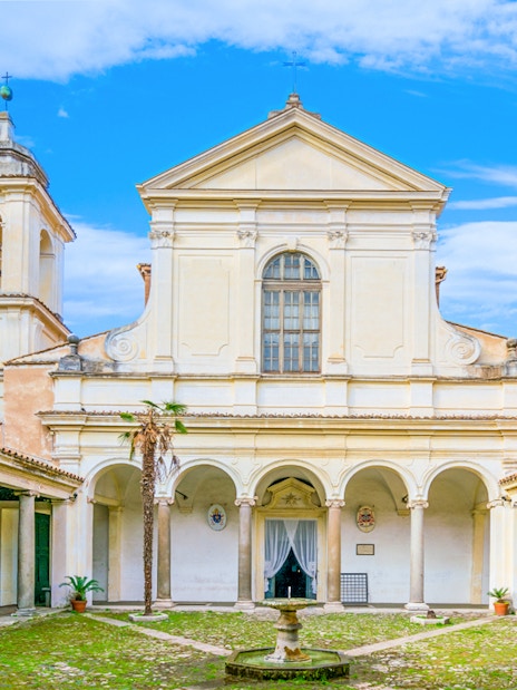 Courtyard of Basilica of San Clemente, Rome, with arches and bell tower.
